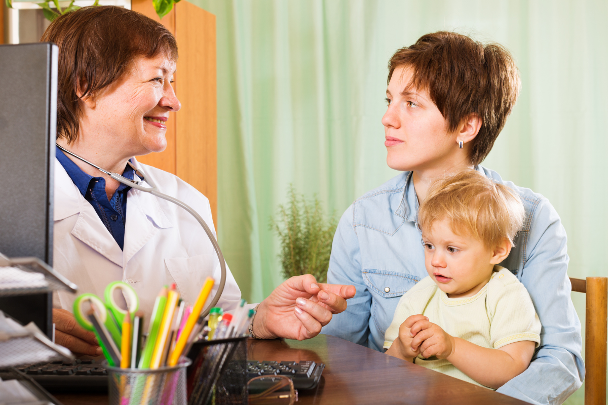 Pediatric oncologist explaining lung cancer symptoms and causes to parents